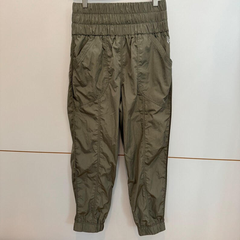 Pu&ograve; includere: Pantaloni cargo verde oliva con vita a coulisse e gambe a polsino.