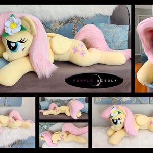 Puede incluir: Un juguete de peluche de Pinkie Pie de My Little Pony, acostado de lado con la cabeza apoyada en una almohada. El juguete es amarillo con pelo rosa y una flor blanca en el pelo. El juguete tiene dise&ntilde;os de mariposas en la espalda. El juguete est&aacute; acostado en un sof&aacute; marr&oacute;n claro.