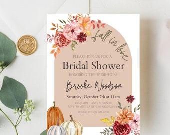 May include: Fall-themed bridal shower invitation with a watercolor floral design in shades of orange, red, and pink. The invitation features a half-circle with the text "fall in love" and the words "Bridal Shower" in a brown font. The invitation also includes the bride-to-be's name, "Brooke Woodson", the date and time of the shower, and the location.