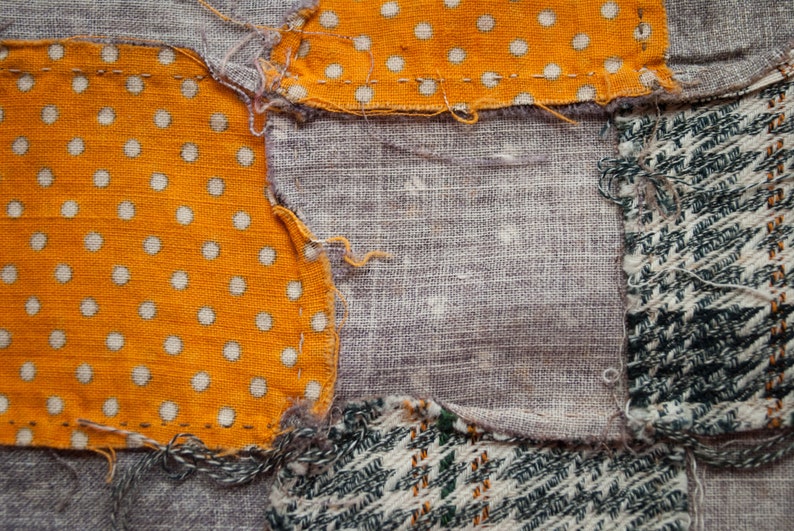 Pu&ograve; includere: Primo piano di un tessuto patchwork con vari motivi di tessuto. Il design include una sezione di tessuto arancione con pois bianchi, lino grigio e un motivo tweed verde e bianco. I pezzi sono cuciti insieme con filo visibile.