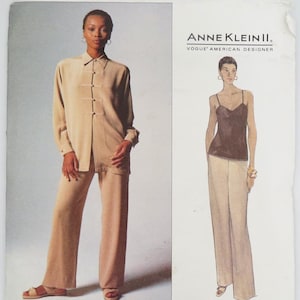 May include: A Vogue sewing pattern featuring two women's outfits. One outfit is a tan button-down shirt and matching pants. The other is a black camisole and tan pants. The pattern is labeled "ANNE KLEIN II" and "Vogue American Designer."