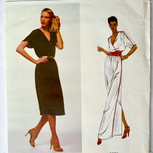 Puede incluir: Patrón de vestido Vogue American Designer, con dos modelos que llevan diferentes estilos de vestido. El vestido de la izquierda es negro con un cinturón dorado, mientras que el vestido de la derecha es blanco con un cinturón rojo. El número del patrón es 2278 y el diseñador es Kasper.