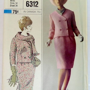 May include: Simplicity sewing pattern number 6312 for a two-piece suit. The pattern is for a miss, size 14, bust 34. The suit is pink and has a double-breasted jacket with a collar and a skirt.