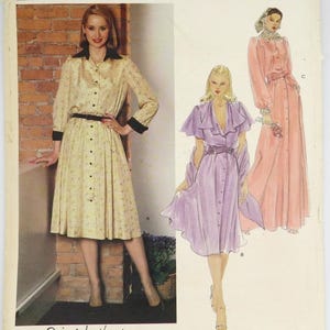 May include: Vogue American Designer sewing pattern featuring a button-down dress with a black collar and cuffs. The pattern includes illustrations of three dress designs in shades of yellow, lavender, and pink. The designer's signature, Edith Head, is visible.