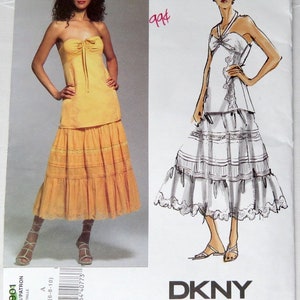 Pode incluir: Um padrão de costura para um top sem alças e uma saia de camadas. O padrão é da Donna Karan New York e é para os tamanhos 6-8-10. O número do padrão é V2901.