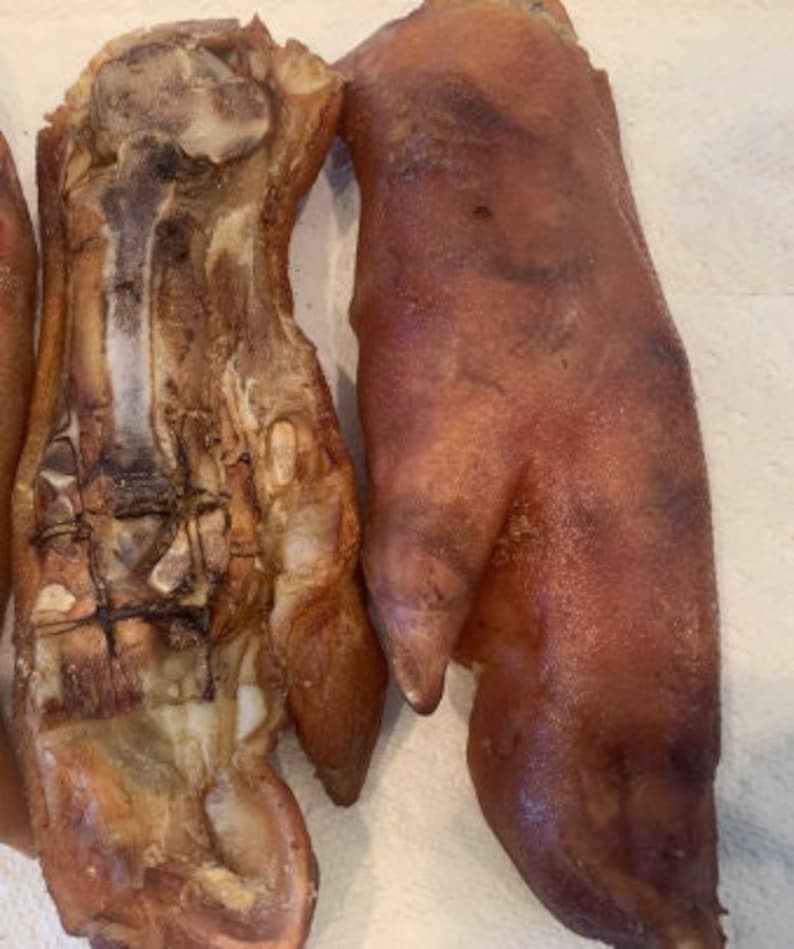 Pode incluir: Duas patas de porco assadas, uma com a pele removida para mostrar a estrutura &oacute;ssea, a outra com a pele intacta.