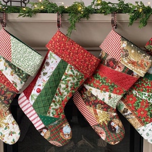 以下が含まれることがあります： クリスマスのストッキングが4つ、パッチワーク生地で作られており、赤と緑の格子柄、ヒイラギ、雪片など、さまざまなホリデーパターンが施されています。ストッキングは白い暖炉の上にかけられています。
