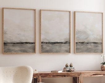 May include: A living room interior with a white armchair, a wooden coffee table, and a wooden console table with two matching wooden storage boxes. Three framed abstract landscape paintings hang on the wall above the console table. Two potted orchid plants are on the floor next to the console table.
