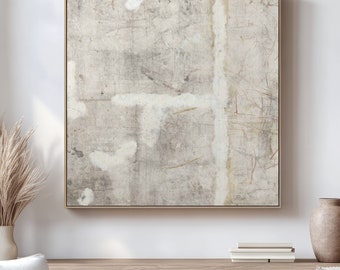 May include: A framed abstract painting with a light gray background and white brushstrokes. The painting is hanging on a white wall above a wooden cabinet.