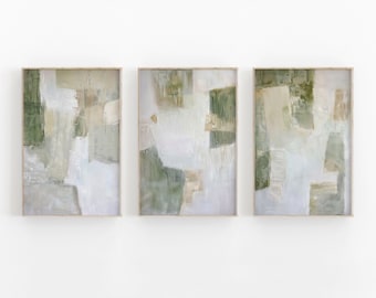May include: Three framed abstract paintings with a muted color palette of green, white, and beige. The paintings are in a modern style and feature geometric shapes and brushstrokes.