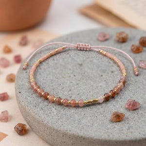 Gepersonaliseerde armband met robijnkwarts en zonnesteen, verguld.