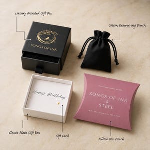 May include: A black luxury branded gift box with a gold bird logo and the text SONGS OF INK, a black cotton drawstring pouch, a white classic plain gift box containing a Happy Birthday gift card, and a mauve pillow box pouch labeled SONGS OF INK & STEEL.
