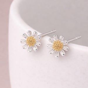 Può includere: Una tazza di ceramica bianca con manico nero e la scritta "But First, Coffee" in grassetto nero. La tazza è posta su uno sfondo sfocato, che suggerisce un'atmosfera accogliente.