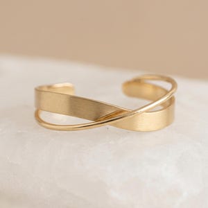 Brazalete cruzado ajustable con baño de oro.