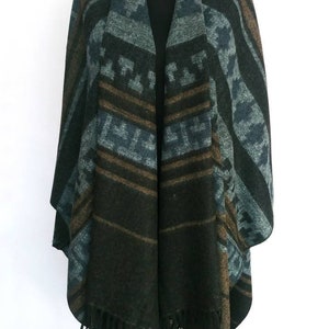 May include: A black, brown, and blue patterned poncho with fringe on the bottom.