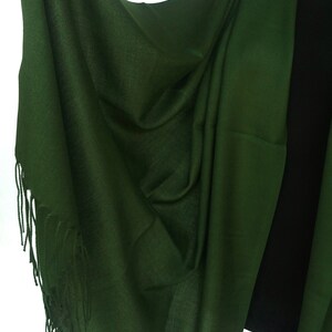 Pu&ograve; includere: Un scialle di pashmina verde scuro con un bordo a frangia. Lo scialle &egrave; drappeggiato su un manichino nero.
