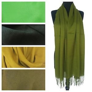 May include: A green, yellow and black scarf with fringe. The scarf is draped over a mannequin.