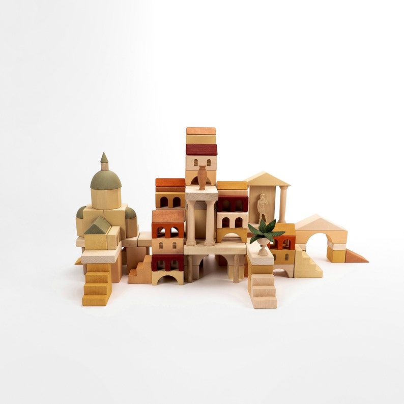 May include: A wooden toy building set with a variety of shapes and sizes. The set includes a tower, a dome, and several smaller buildings. The buildings are made of natural wood and have a light brown color. The set is perfect for imaginative play and can be used to create a variety of different structures.