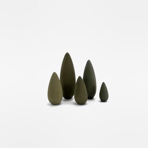 May include: A set of five wooden teardrop-shaped ornaments in shades of green. The ornaments are arranged in a staggered formation, with the largest ornament in the center and the smallest ornament on the right.