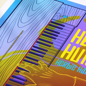 May include: A yellow and blue poster with the text "Heavy Hustle" and "Herbie Hancock" in a bold, blocky font. The poster features a hand playing a keyboard with a wooden case.