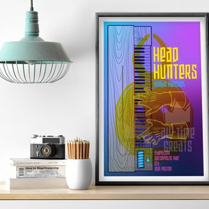 May include: A colorful poster with a graphic illustration of a keyboard and hands playing it. The text "Head Hunters" and "Herbie Hancock" are featured in yellow. The poster has a blue, purple, and pink gradient background.
