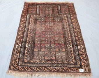 May include: Rectangular, hand-woven rug with a central geometric design in shades of red, brown, and beige. The rug features a detailed border with repeating patterns and fringe along the edges. The rug's dimensions are approximately 3 x 5 feet.