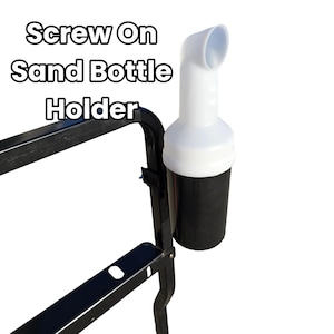 May include: A black and white screw-on sand bottle holder. The holder is attached to a black metal frame. The bottle holder is white with a black cup. The text "Screw On Sand Bottle Holder" is in the image.