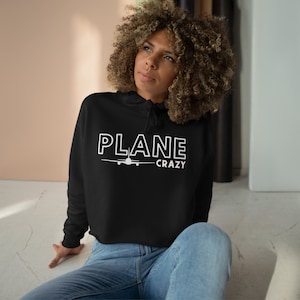May include: A black cropped hoodie with a white airplane graphic and the text "PLANE CRAZY".