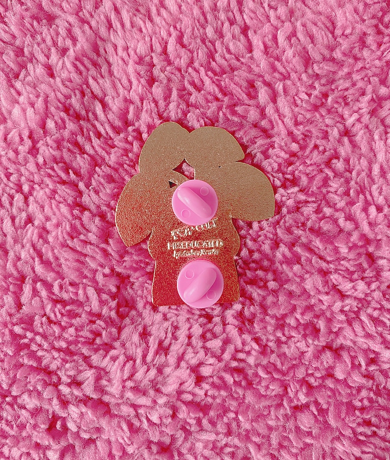 May include: Gold-colored metal pin shaped like a tree with the text "FOR COLD MISLUCK" and the words "by ColorKute" underneath. The pin has two pink plastic butterfly backings.
