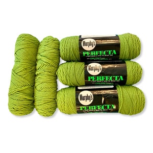 Op de afbeelding: Zes bollen groene garen met het label "Murphy's Perfecta 70% Orlon/30% Wol"