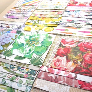 Op de afbeelding: Een stapel kleurrijke papieren servetten met bloemen- en geometrische patronen. De servetten zijn gevouwen en netjes gestapeld.