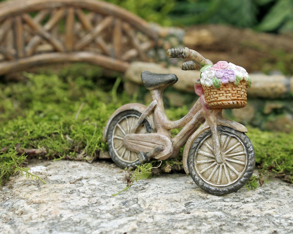 Basket of flowers on trunk of an old bicycle. Provence style garden decor.  Flower delivery. Online ordering at a flower shop. Reuse of things, the  second life of the bike Stock Photo -