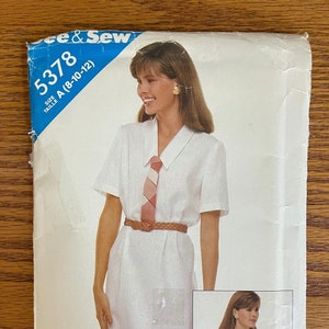 May include: A vintage sewing pattern titled "See & Sew" with the number 5378. The pattern features a woman wearing a white dress with a tie and a tan blazer. The size is A (8-10-12).