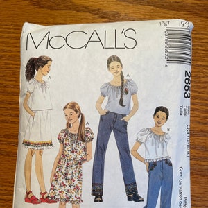 May include: McCall's sewing pattern envelope featuring illustrations of girls' outfits. The designs include tops, skirts, and pants with floral and embroidered details. The envelope has the number 2653 and the McCall's logo.