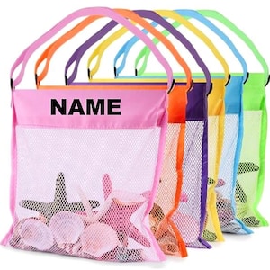 May include: A row of colorful mesh beach bags with handles. Each bag is a different color, including pink, orange, purple, yellow, blue, and green. The bags are filled with seashells and starfish. The word "NAME" is printed on the pink bag.