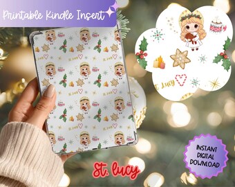 May include: A clear Kindle insert featuring a repeating pattern of St. Lucy, gingerbread stars, holly leaves, candy canes, and hot cocoa mugs on a white background. The text "St. Lucy" is printed in gold script throughout the design.