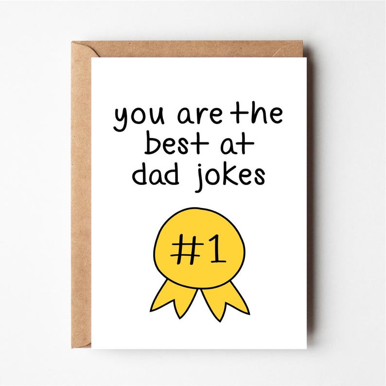 Puede incluir: Una tarjeta blanca con texto negro que dice "you are +the best +at dad jokes" y una cinta amarilla con un n&uacute;mero uno negro en su interior. La tarjeta es una tarjeta de felicitaci&oacute;n divertida para un padre.