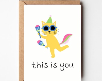 May include: A greeting card with a yellow cat wearing sunglasses and a party hat, holding maracas. The cat has a pink, green, and white tail. The text "this is you" is written below the cat.