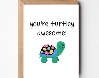 May include: A white card with the text "you're turtley awesome!" in black. A green turtle with a colorful shell is illustrated below the text.