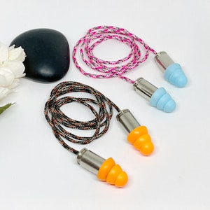 May include: Two pairs of earplugs with different colored cords. One pair has a black and orange cord and orange earplugs. The other pair has a pink and white cord and blue earplugs.