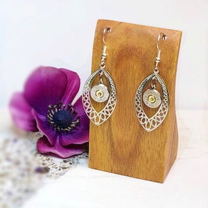 May include: Silver filigree earrings with a bullet charm. The bullet is a Winchester 22 SPL.