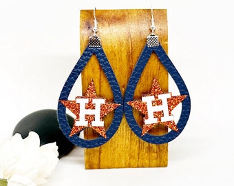 May include: A pair of blue teardrop-shaped earrings with a white "H" inside a red glitter star.