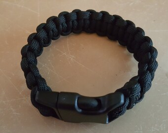 May include: A black paracord bracelet with a black plastic clasp.
