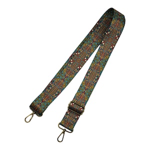 May include: A teal, red, and gold patterned adjustable strap with brass hardware. The strap is made of woven fabric and has a geometric design.