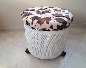 A "cow" metal stool on wheels with storage space from a washing machine drum