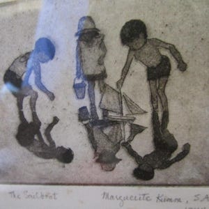 Puede incluir: Un grabado enmarcado titulado "The Sailboat" representa a tres niños en la playa. Uno sostiene un cubo, otro un velero de juguete. La obra de arte es en blanco y negro, con los reflejos de los niños visibles.