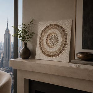 May include: A square wall art piece featuring a central spiral design surrounded by concentric circles of textured brown and cream patterns. The artwork has a raised, tactile surface with intricate line work and organic shapes in neutral tones.