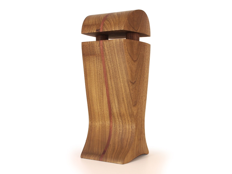 K&ouml;nnte beinhalten: Eine Holzvase mit einem einzigartigen, geschwungenen Design. Die Vase ist aus Walnussholz mit einer roten Holzeinlage. Die Vase hat einen abnehmbaren Deckel.