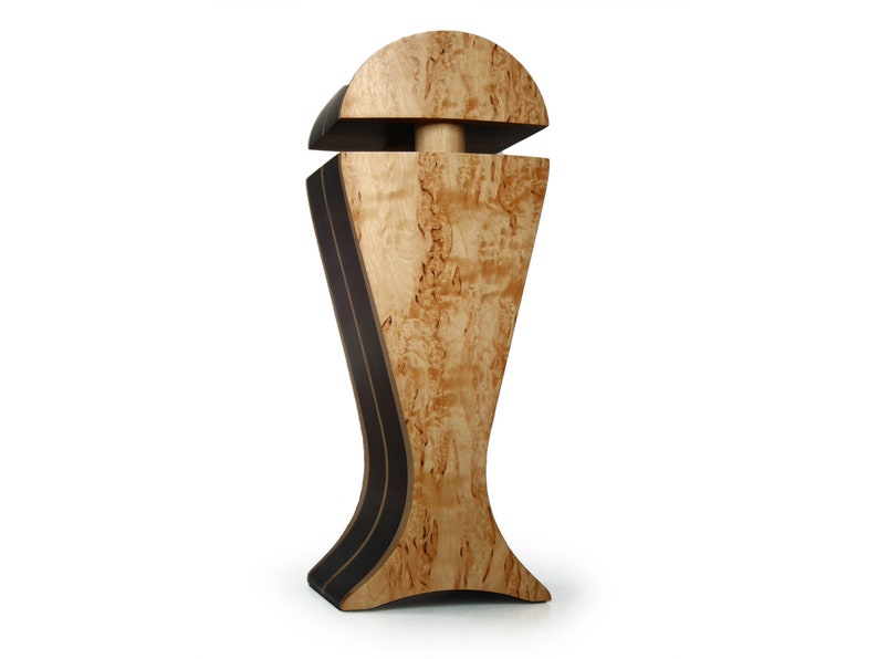 May include: A wooden decorative vase with a unique design. The vase is made of light wood with dark brown accents and has a rounded top and a wide base.