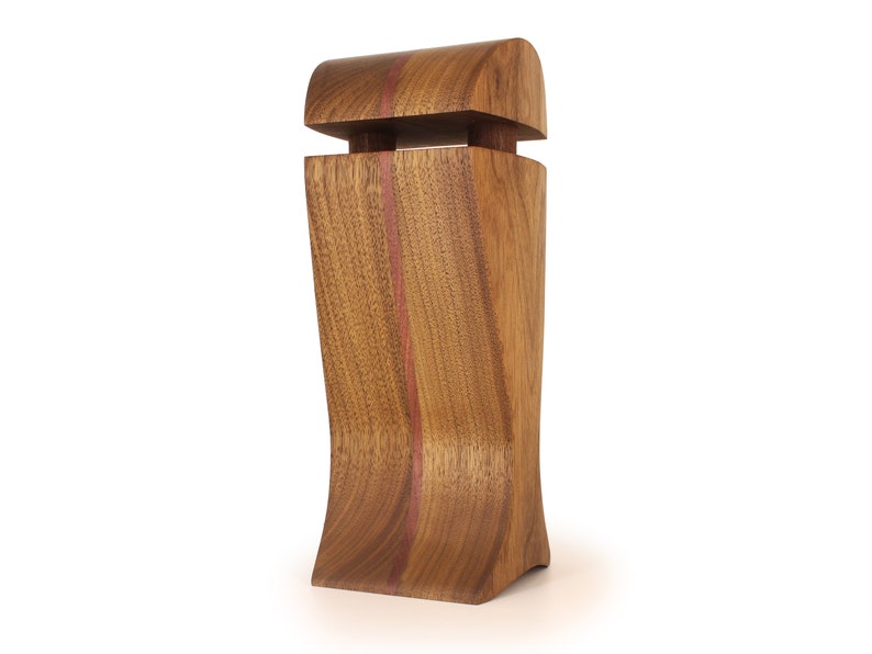 K&ouml;nnte beinhalten: Eine Holzkiste mit einem geschwungenen Design und einem kontrastierenden roten Streifen. Die Kiste hat einen Klappdeckel und eine glatte Oberfl&auml;che.